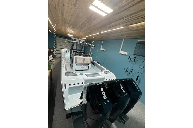 Slide: The Image of 2024 Front Runner boat with triple 400 HP engines in a wooden-ceiling garage. - 5
