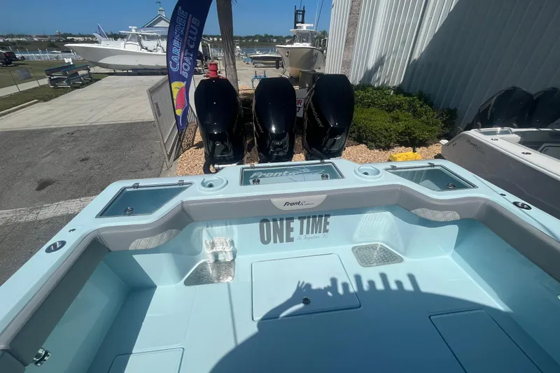 Slide: The Image of 2024 Front Runner boat with triple Mercury engines at a marina display. - 6