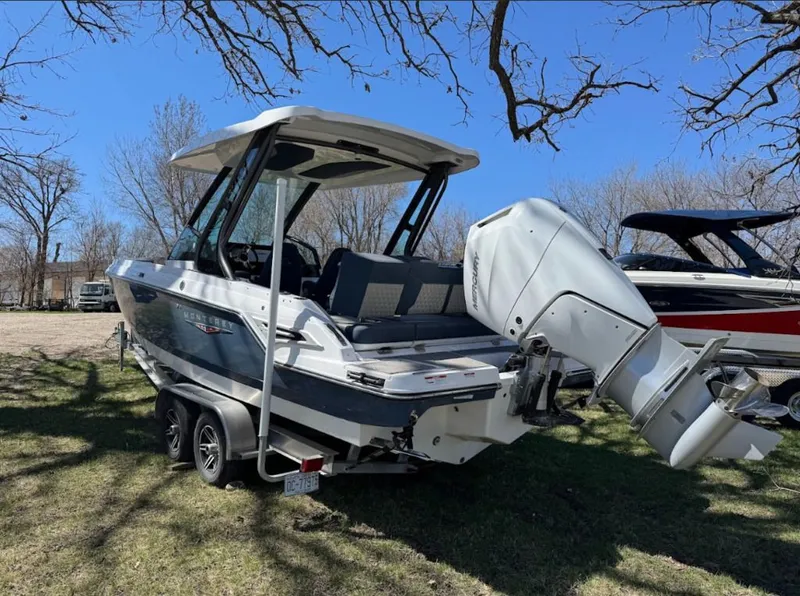 Slide: The Image of 2025 Monterey Elite 27 OB boat parked on trailer outdoors. - 2