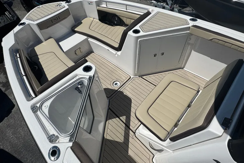 Slide: The Image of 2026 Yamaha Boats 255 FSH Sport E interior with beige seating and storage compartments. - 11