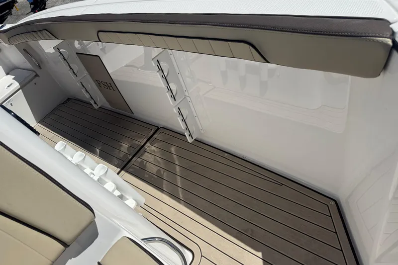 Slide: The Image of 2026 Yamaha Boats 255 FSH Sport E interior with cushioned seating and rod holders. - 25