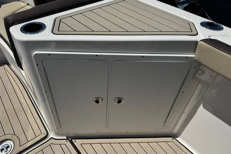 Slide: The Image of 2026 Yamaha Boats 255 FSH Sport E deck with storage compartment and cup holders. - 23