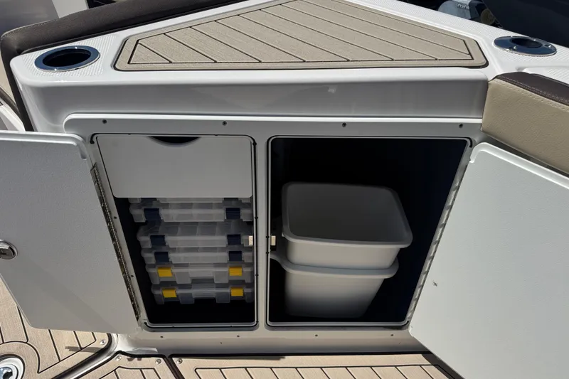 Slide: The Image of 2026 Yamaha Boats 255 FSH Sport E storage compartments with tackle boxes and bins. - 24
