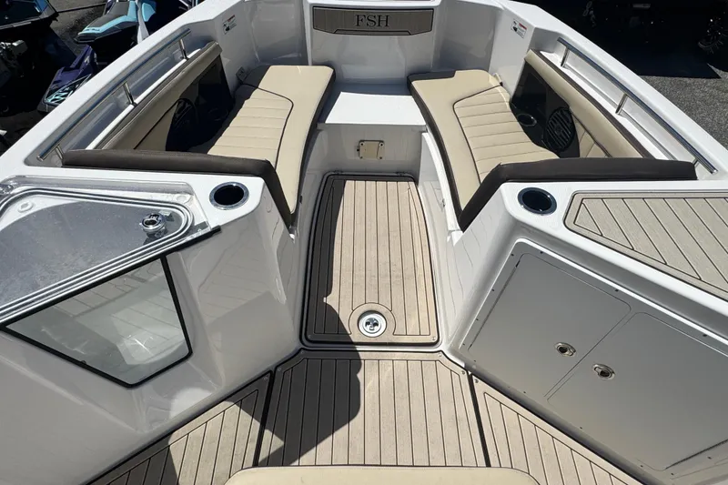Slide: The Image of 2026 Yamaha Boats 255 FSH Sport E interior with beige seating and cup holders. - 12