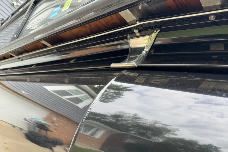 Slide: The Image of Close-up of a 2024 Regency 230 DL3 boat detail, showcasing sleek black exterior. - 11