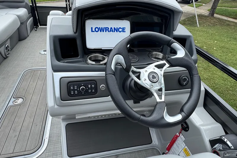 Slide: The Image of 2024 Regency 230 DL3 boat dashboard with steering wheel and Lowrance display. - 18