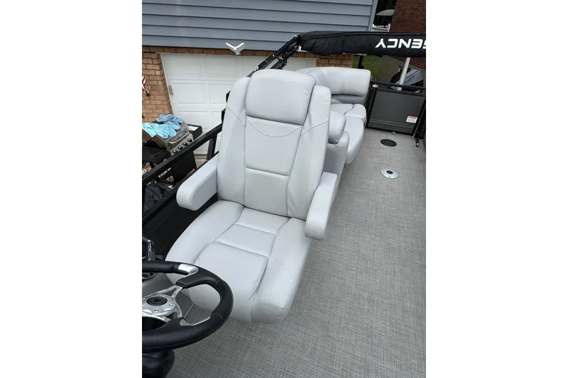 Slide: The Image of 2024 Regency 230 DL3 boat interior with plush gray seating and steering wheel. - 19