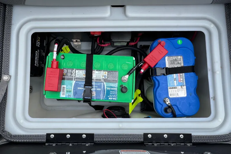 Slide: The Image of Battery compartment of 2024 Regency 230 DL3 with green and blue batteries. - 23