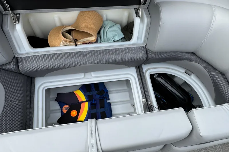 Slide: The Image of 2024 Regency 230 DL3 boat storage compartments with life jacket and hat. - 28
