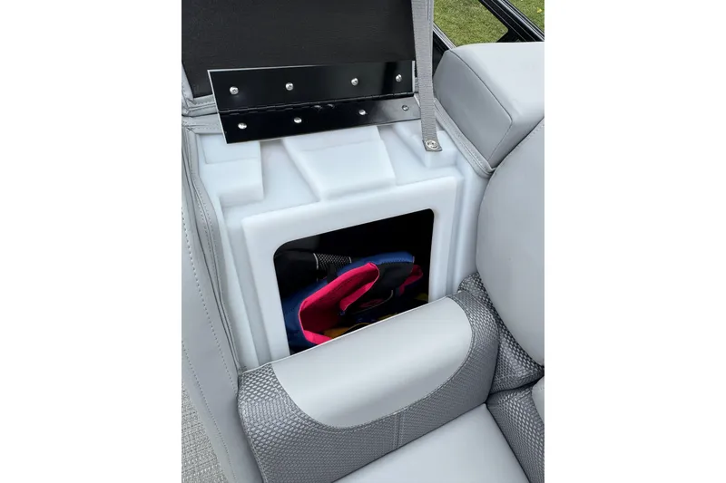 Slide: The Image of 2024 Regency 230 DL3 boat seat storage compartment with visible life jackets. - 29