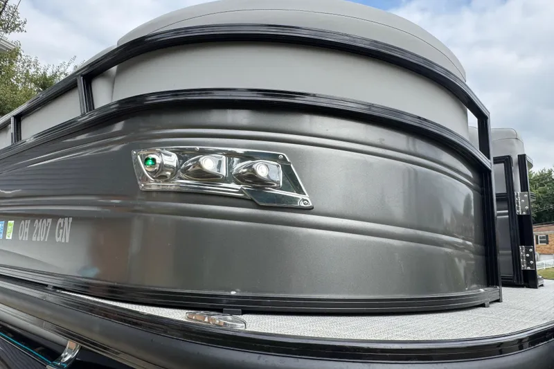 Slide: The Image of 2024 Regency 230 DL3 pontoon boat, sleek metallic exterior, close-up view. - 40