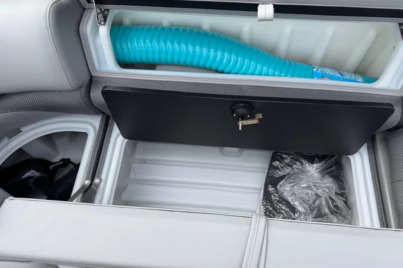 Slide: The Image of 2024 Regency 230 DL3 boat storage compartment with blue hose and accessories. - 41