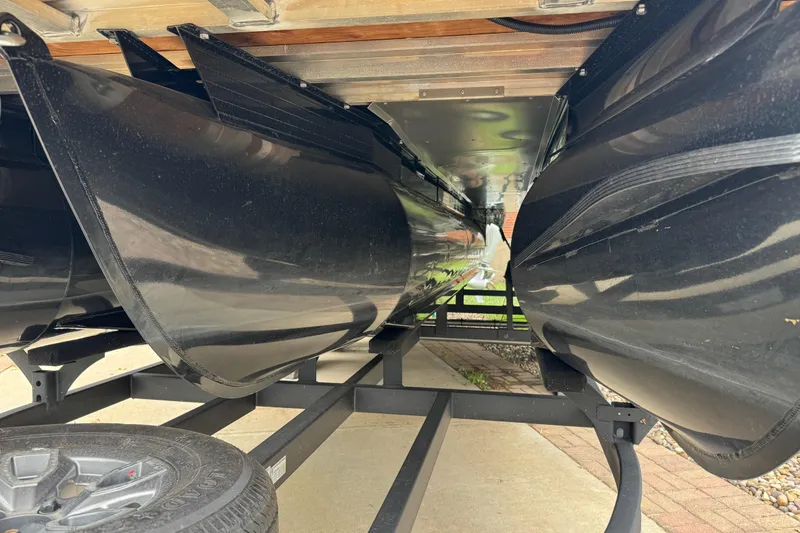 Slide: The Image of Underneath view of a 2024 Regency 230 DL3 pontoon boat on a trailer. - 43