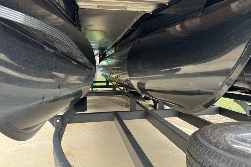 Slide: The Image of Underneath view of a 2024 Regency 230 DL3 pontoon boat on a trailer. - 44