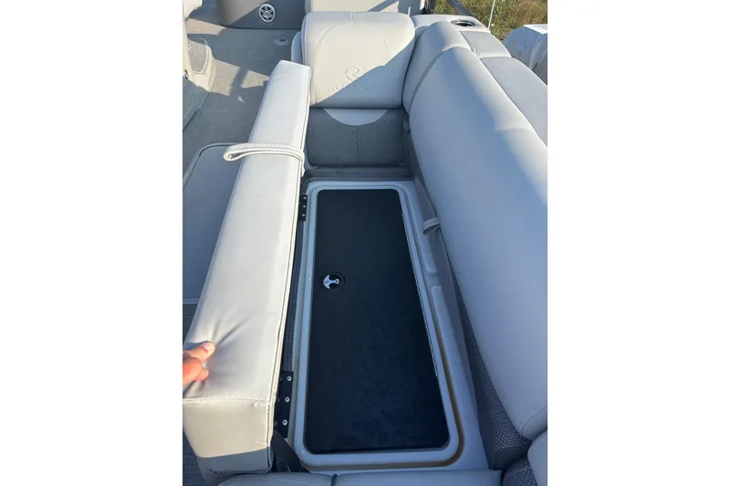 Slide: The Image of 2021 Regency 250 DL3 boat seat storage compartment open, revealing interior space. - 10