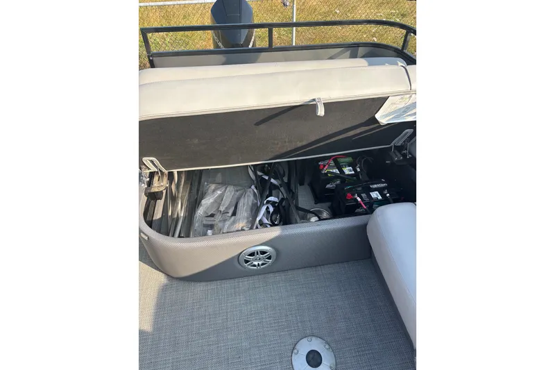 Slide: The Image of Open storage compartment in 2021 Regency 250 DL3 boat, revealing batteries and equipment. - 13