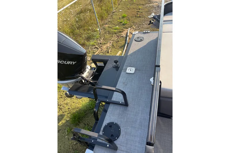 Slide: The Image of 2021 Regency 250 DL3 boat with Mercury outboard motor, docked on grassy shore. - 19