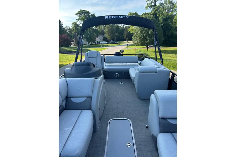 Slide: The Image of 2021 Regency 250 DL3 pontoon boat interior with plush seating and canopy. - 4