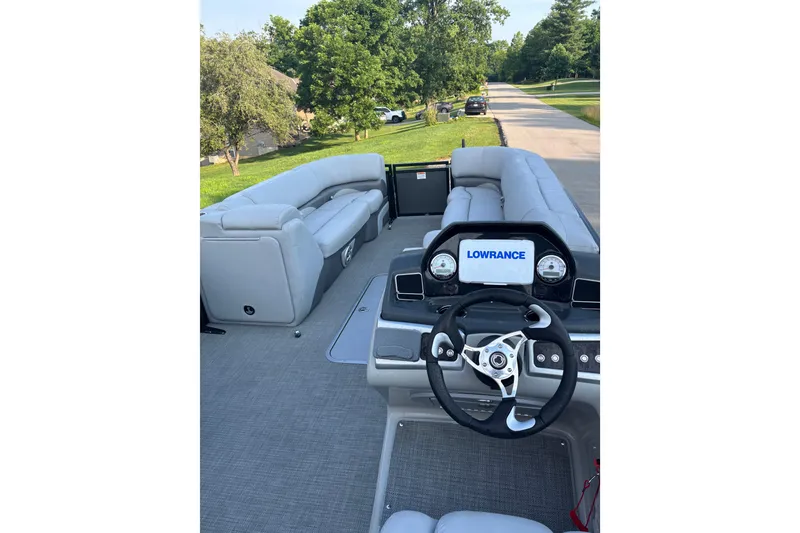 Slide: The Image of 2021 Regency 250 DL3 pontoon boat interior with steering wheel and seating. - 5