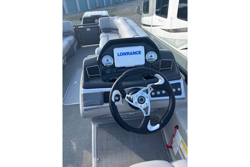 Slide: The Image of 2021 Regency 250 DL3 boat dashboard with steering wheel and Lowrance display. - 8