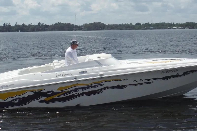 The Image of 2001 Powerquest 280 Silencer boat on a calm lake with a person onboard. - 1