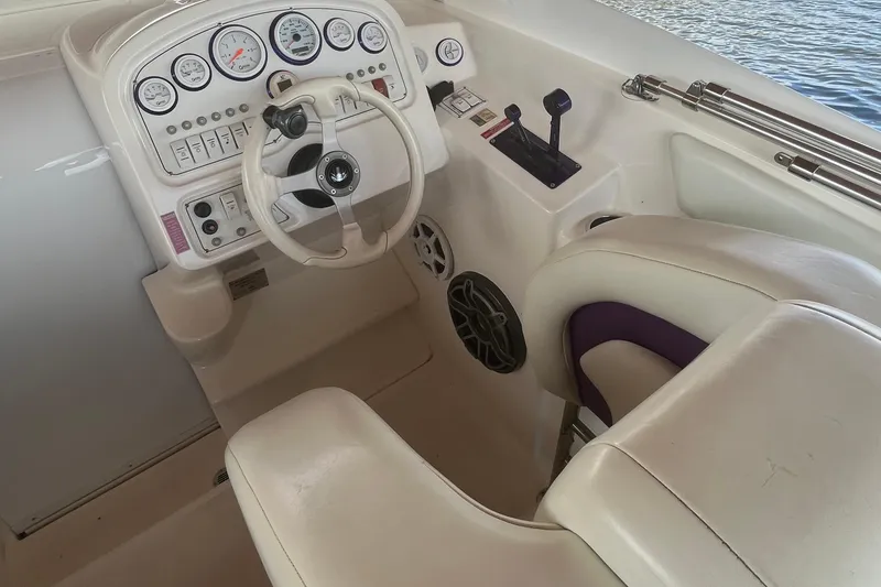 Slide: The Image of 2001 Powerquest 280 Silencer boat cockpit with steering wheel and control panel. - 12