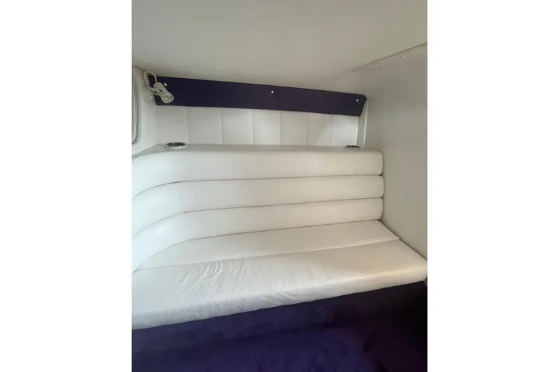 Slide: The Image of Interior seating of 2001 Powerquest 280 Silencer boat, featuring white cushioned upholstery. - 18