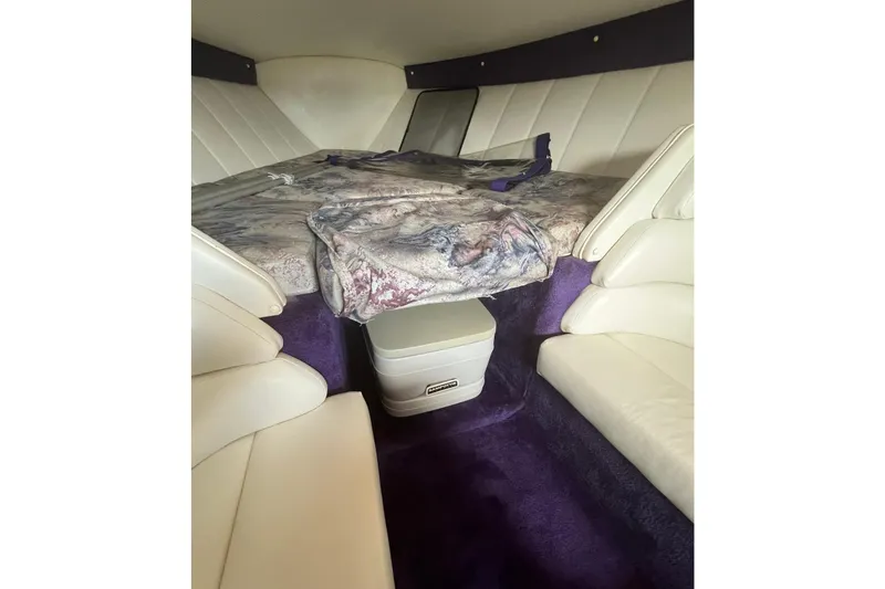 Slide: The Image of Interior cabin of a 2001 Powerquest 280 Silencer boat with white seating and purple accents. - 20