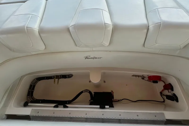 Slide: The Image of 2001 Powerquest 280 Silencer boat interior storage compartment with visible wiring and components. - 22