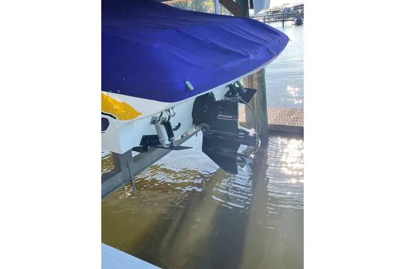 Slide: The Image of 2001 Powerquest 280 Silencer boat with blue cover, docked by the water. - 25