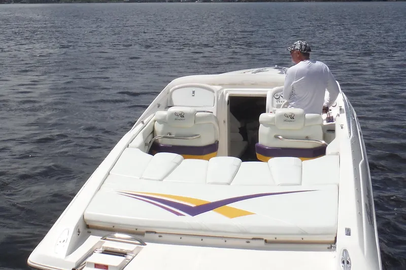 Slide: The Image of 2001 Powerquest 280 Silencer boat on water, featuring sleek white and purple design. - 3