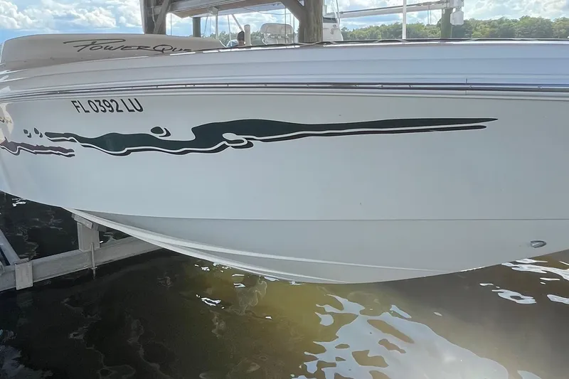 Slide: The Image of 2001 Powerquest 280 Silencer boat docked, featuring sleek design and distinctive graphics. - 5