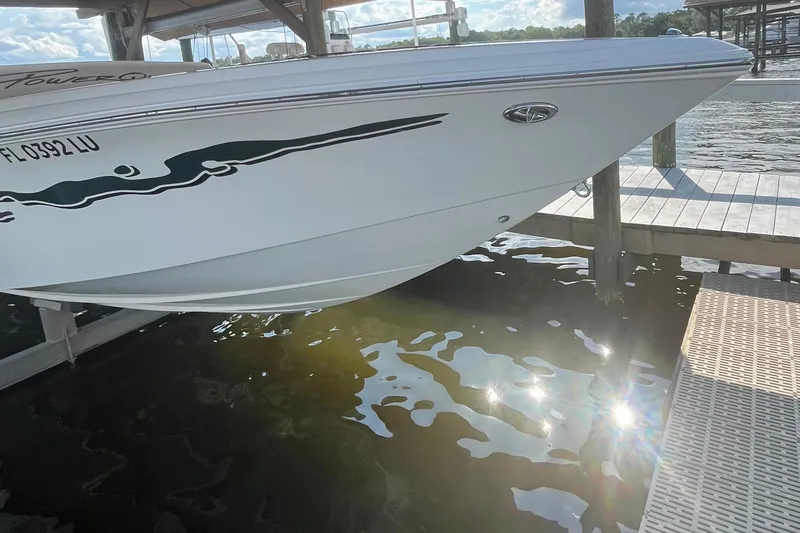 Slide: The Image of 2001 Powerquest 280 Silencer boat docked, reflecting sunlight on water. - 6