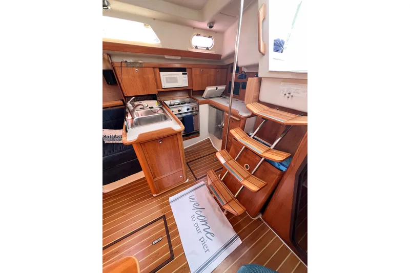 Slide: The Image of Interior of 2005 Catalina 350 sailboat with wooden cabinetry and compact kitchen. - 19