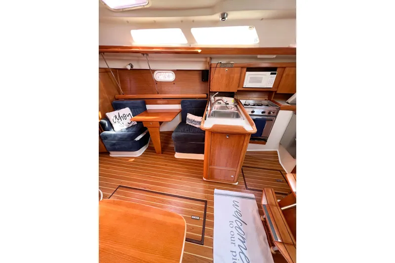 Slide: The Image of Interior of 2005 Catalina 350 sailboat with cozy seating and compact kitchen area. - 20