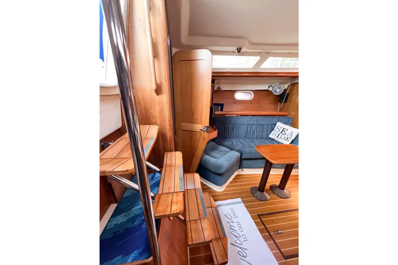 Slide: The Image of Interior of 2005 Catalina 350 sailboat with wooden finishes and cozy seating area. - 26