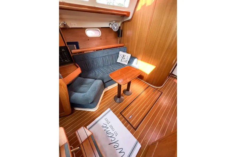 Slide: The Image of Interior of 2005 Catalina 350 sailboat with wooden flooring and cozy seating area. - 27