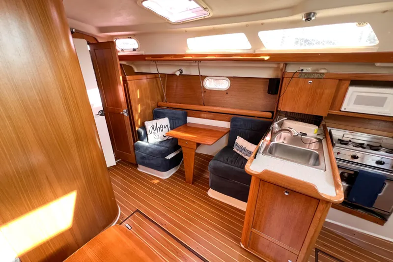 Slide: The Image of Interior of 2005 Catalina 350 sailboat with wood finish, kitchenette, and seating area. - 28