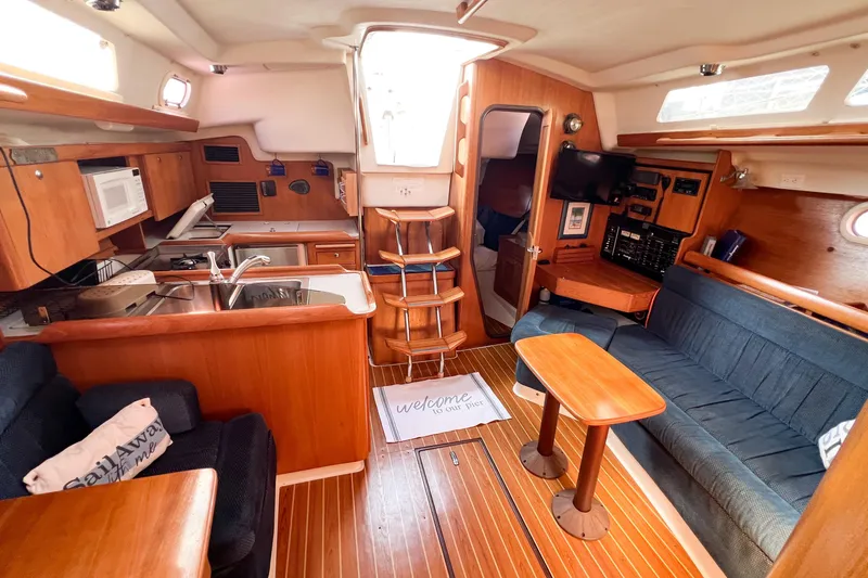 Slide: The Image of Interior of a 2005 Catalina 350 sailboat with cozy seating and kitchen area. - 29