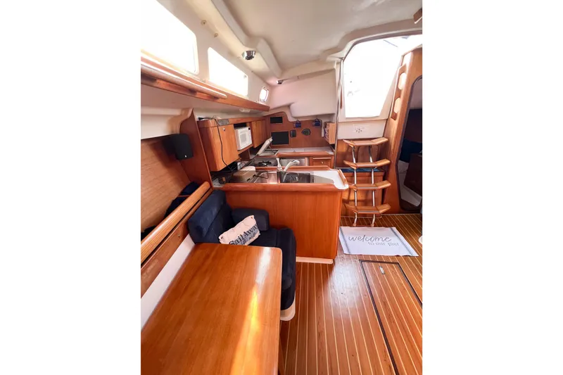 Slide: The Image of Interior of 2005 Catalina 350 sailboat with wooden cabinetry and cozy seating area. - 30
