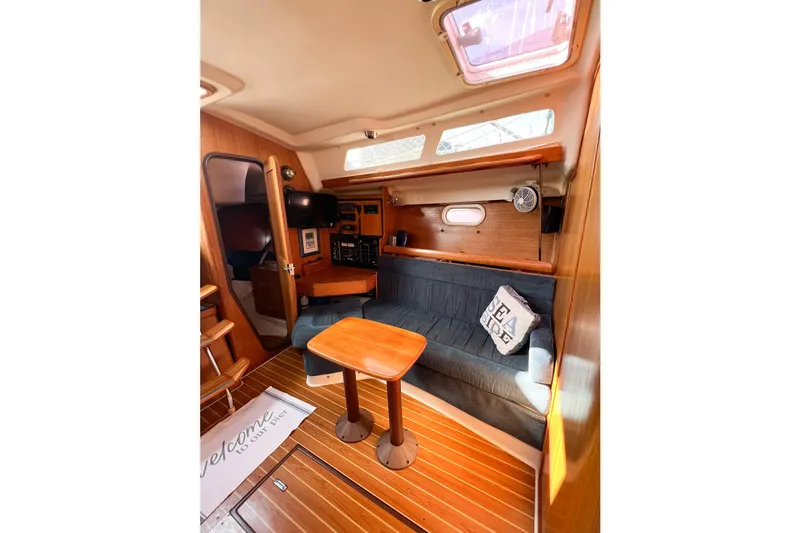 Slide: The Image of Interior of 2005 Catalina 350 sailboat with cozy seating and wooden table. - 32