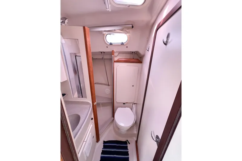 Slide: The Image of Compact bathroom in a 2005 Catalina 350 sailboat, featuring a toilet and sink. - 34
