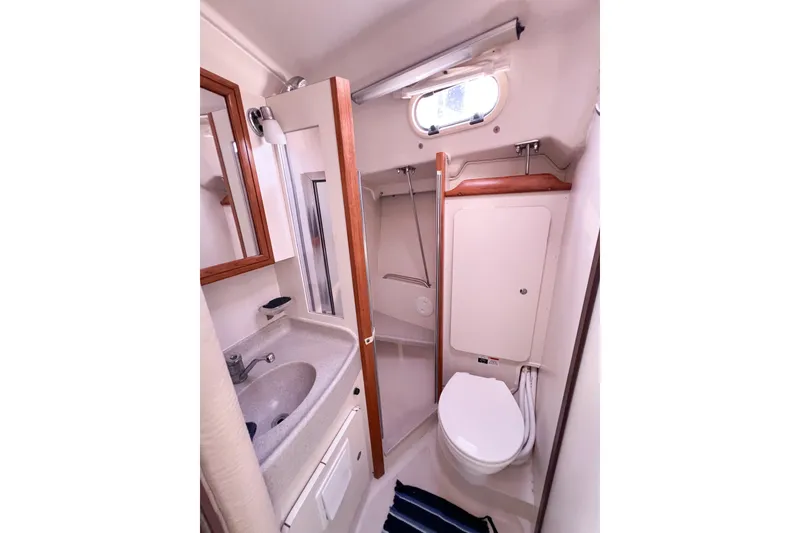Slide: The Image of Compact bathroom in a 2005 Catalina 350 sailboat, featuring sink, toilet, and storage. - 35