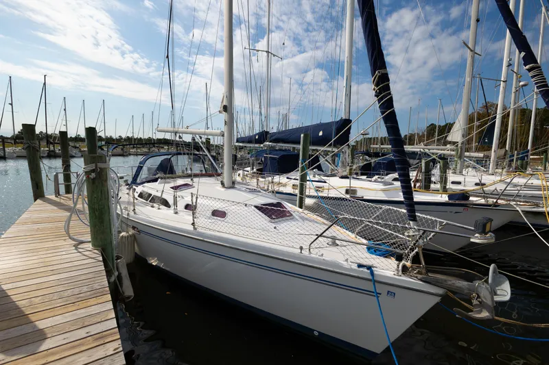 Slide: The Image of 2005 Catalina 350 sailboat docked at a marina under a partly cloudy sky. - 4