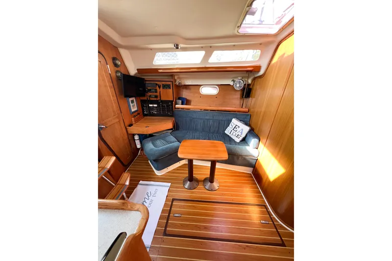 Slide: The Image of Interior of a 2005 Catalina 350 sailboat with cozy seating and wooden finishes. - 41