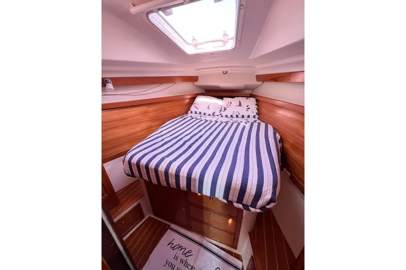 Slide: The Image of Cozy cabin interior of 2005 Catalina 350 sailboat with striped bedding and wooden accents. - 42