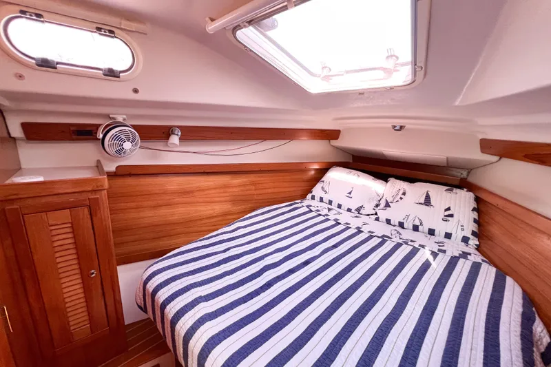 Slide: The Image of Cozy cabin interior of a 2005 Catalina 350 sailboat with striped bedding. - 43