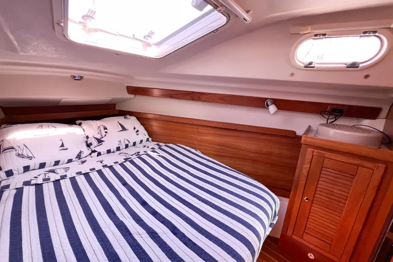 Slide: The Image of Cozy cabin interior of a 2005 Catalina 350 sailboat with nautical-themed bedding. - 44