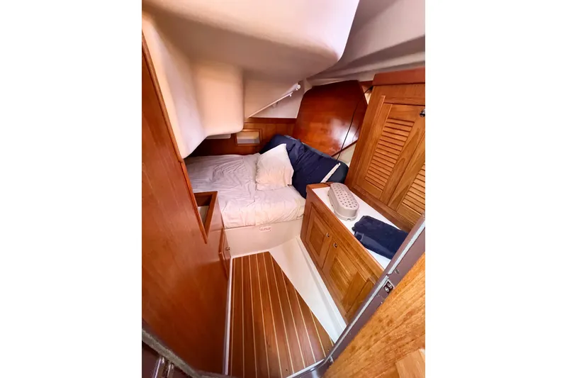 Slide: The Image of Cozy cabin interior of 2005 Catalina 350 sailboat with wooden furnishings and bedding. - 46