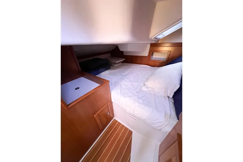 Slide: The Image of Cozy cabin interior of 2005 Catalina 350 sailboat with wooden accents and bedding. - 49